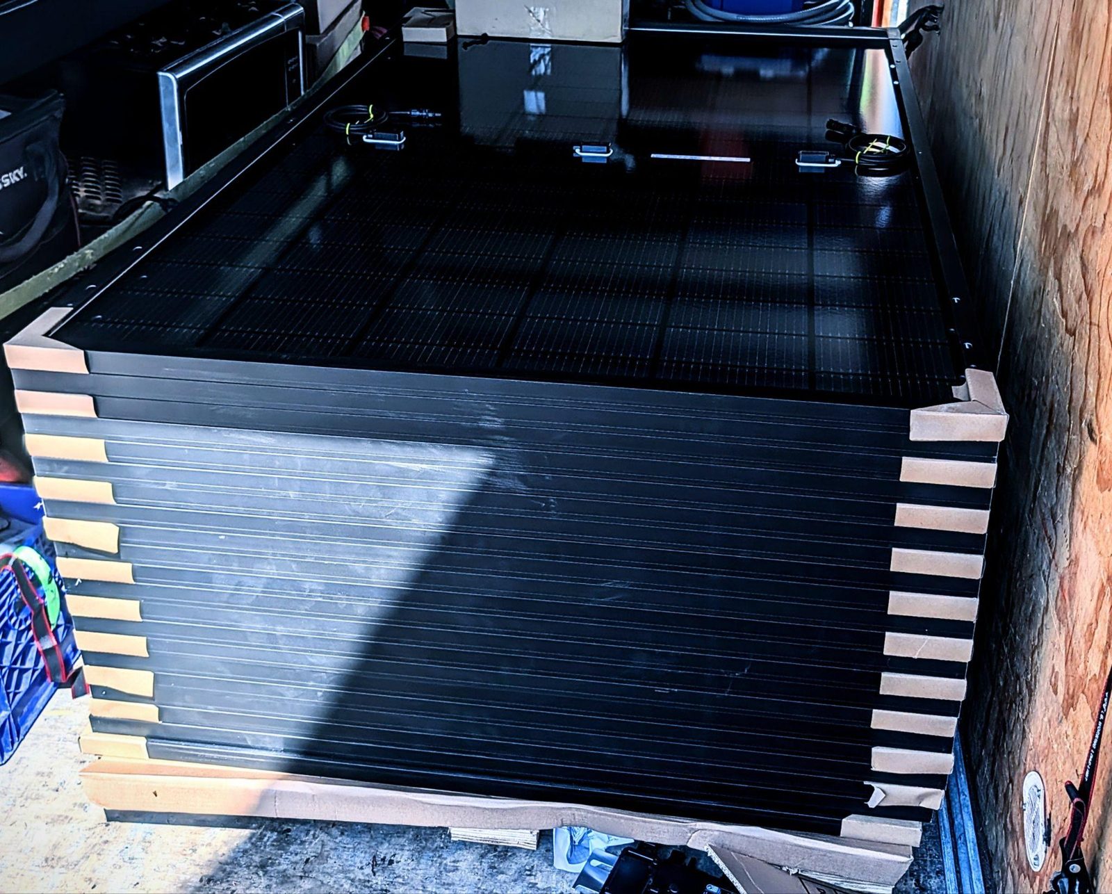 A pallet of all-black solar panels ready for a Shore Home and Solar install